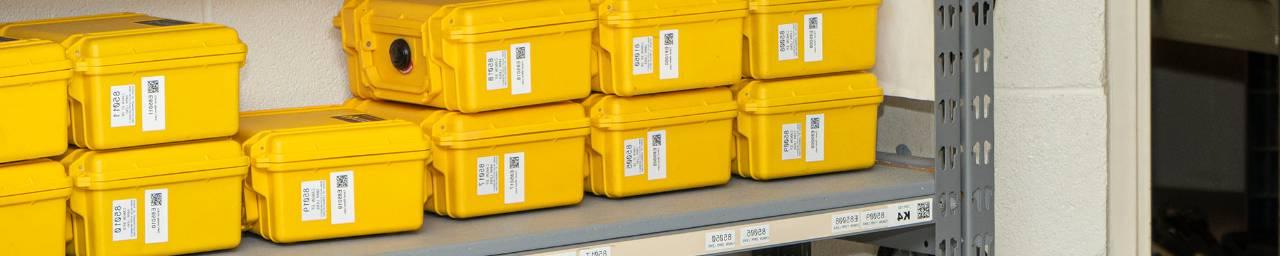 Yellow cases stacked on a storage shelf